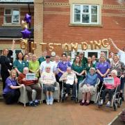 Staff and residents celebrate the outstanding rating outside Cedars Place