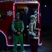 Santa pictured with his elf in front of the bus which visited the Sible Hedingham switch-on last week