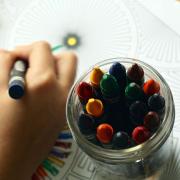 Child care - an illustrative image of a child using crayons to colour in a drawing